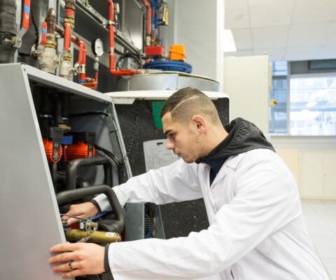 Apprenti travaillant sur une pompe à chaleur dans le cadre de son BTS Fluides-Energie-Domotique option A : génie climatique et fluidique.