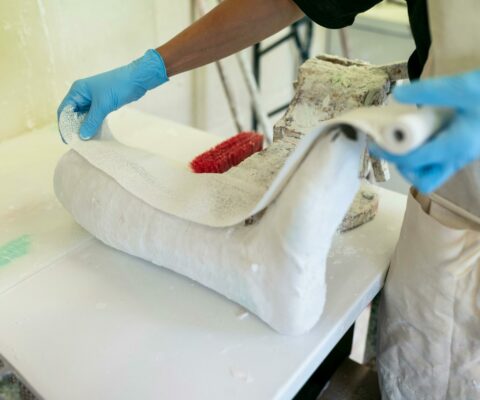 Stagiaire prenant des mesures et effectuant un moulage pour la création d'une orthèse.