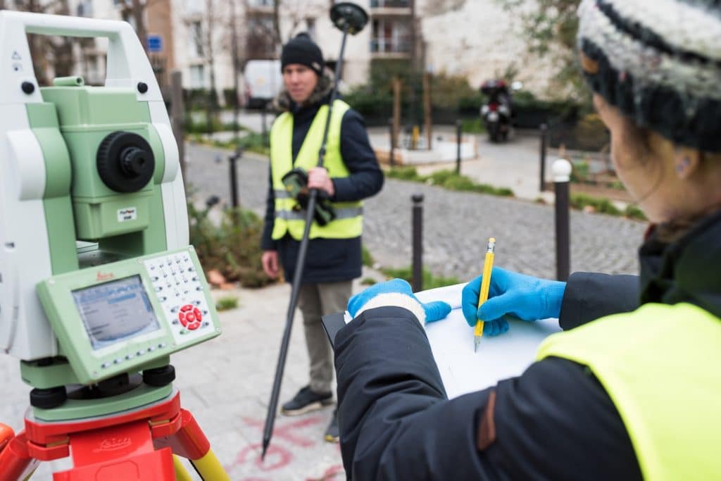Apprentis relevant les mesures du terrain grâce à une station totale et un GNSS.
