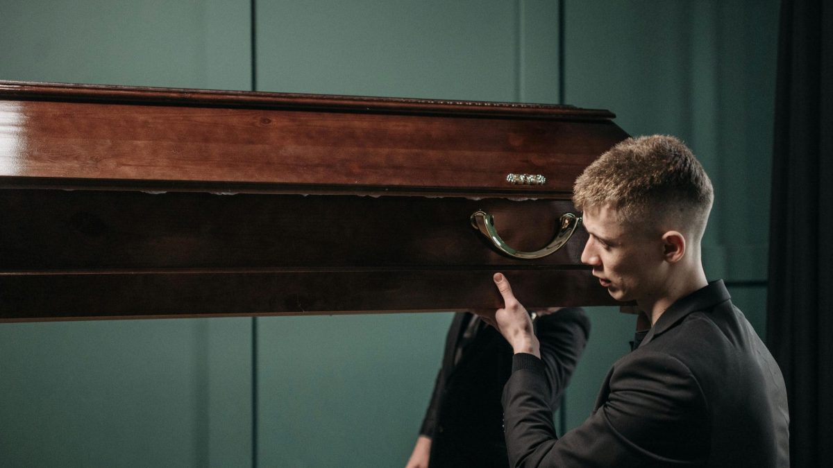 Stagiaire en formation technicien de convoi funéraire portant un cercueil.